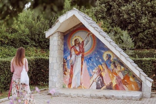 Imagen de mujer frente a fresco religioso