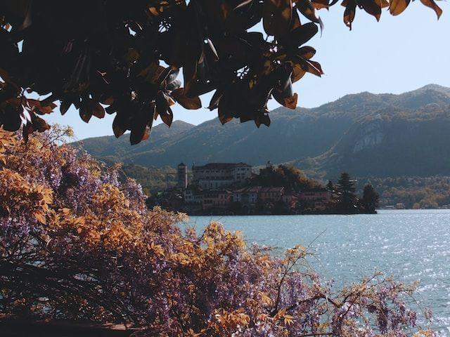 Buildings surrounded by a mirror of water, vegetation and mountains